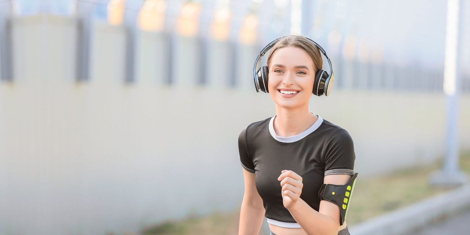 Woman wearing headphones outdoors with a blurred background
